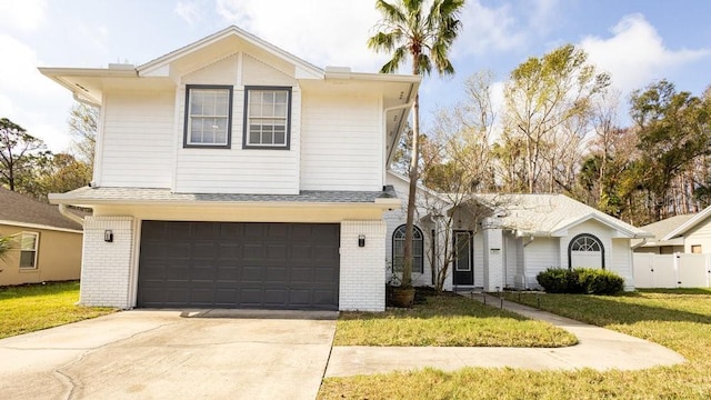 view of property with a garage and a front lawn