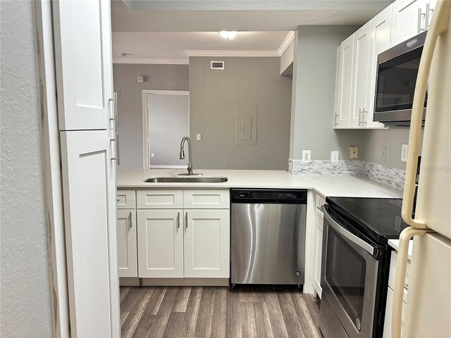 kitchen featuring dark wood-type flooring, sink, crown molding, stainless steel appliances, and white cabinets