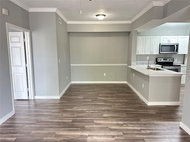 kitchen with appliances with stainless steel finishes, sink, white cabinets, kitchen peninsula, and dark wood-type flooring