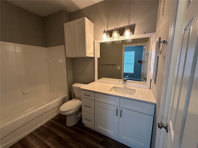 full bathroom with hardwood / wood-style flooring, vanity, toilet, and shower / washtub combination