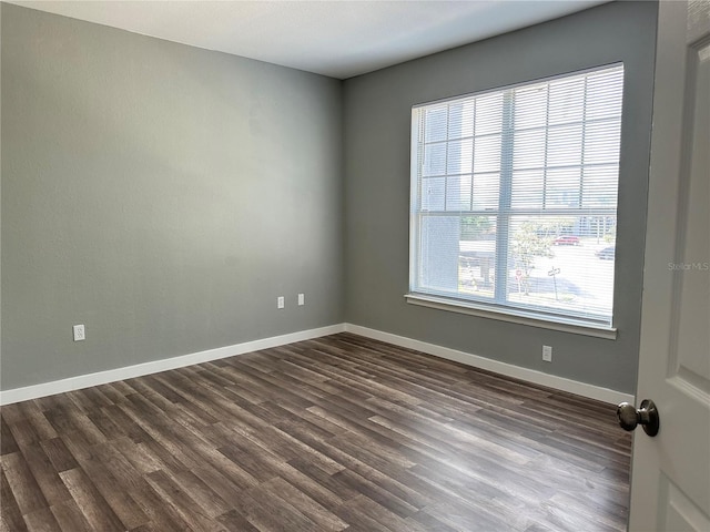 unfurnished room with dark hardwood / wood-style flooring