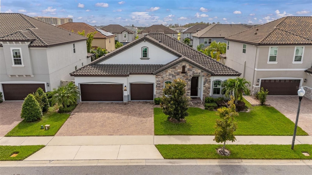 mediterranean / spanish-style home featuring a garage and a front yard