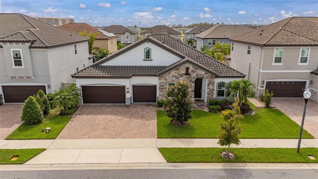 mediterranean / spanish-style home featuring a garage and a front yard