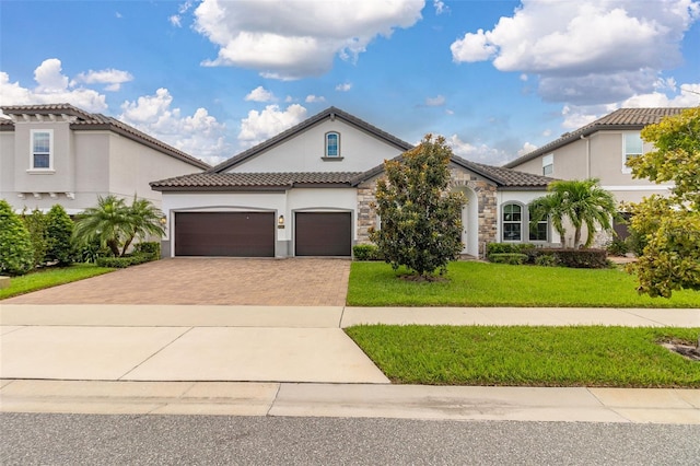 mediterranean / spanish-style house featuring a garage and a front lawn