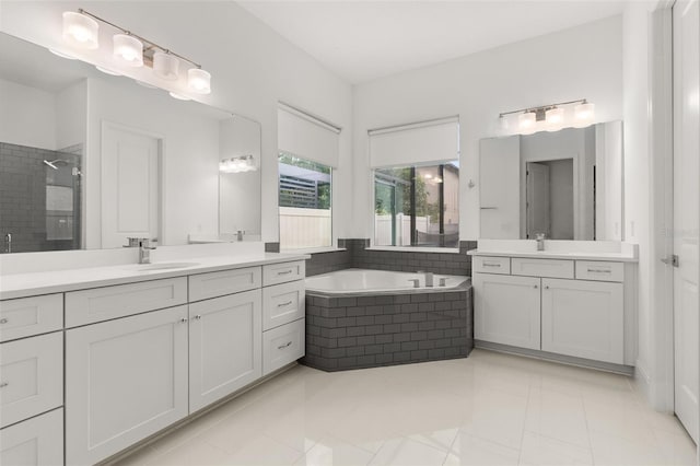 bathroom with independent shower and bath, vanity, and tile patterned floors