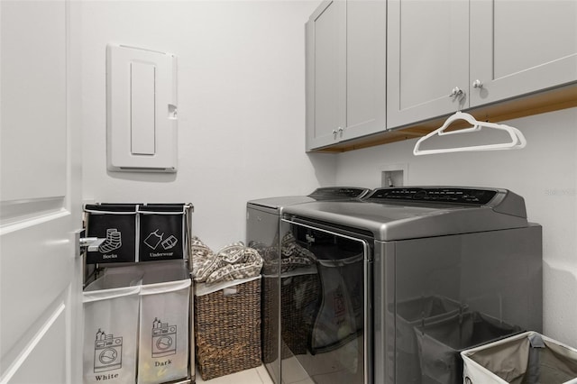 clothes washing area with cabinets, electric panel, and independent washer and dryer