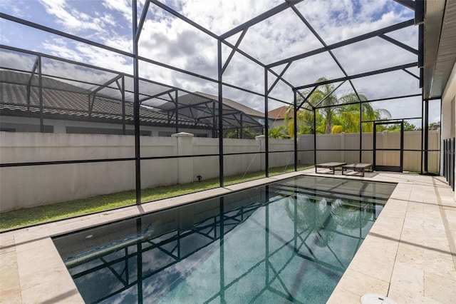 view of pool with glass enclosure and a patio area