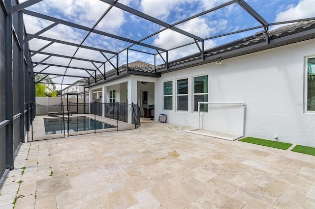 view of swimming pool with glass enclosure and a patio