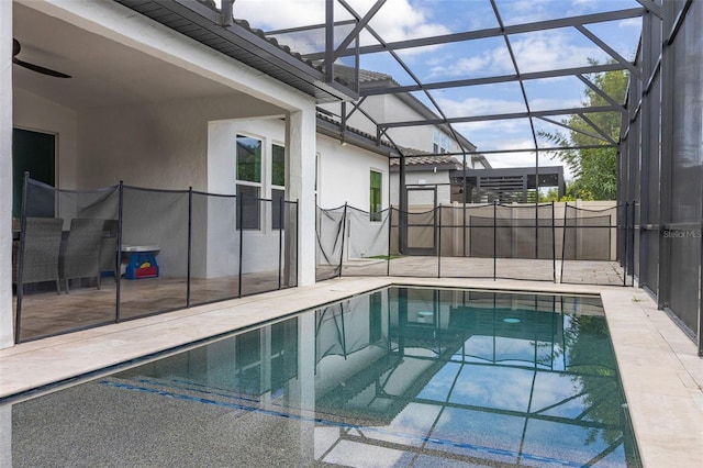 view of pool with glass enclosure and a patio area