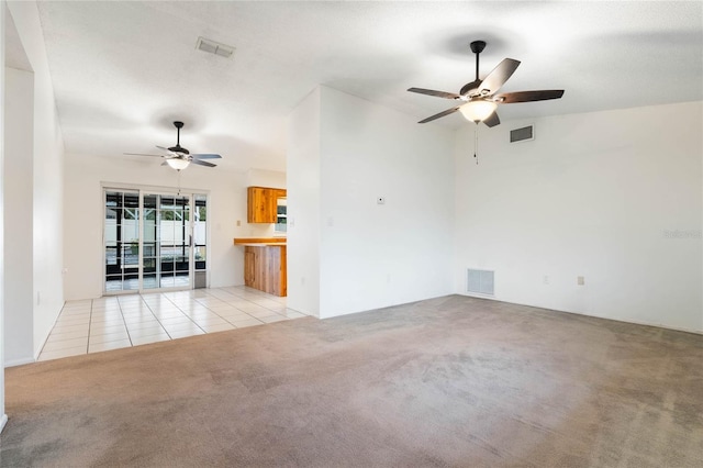 unfurnished living room featuring a textured ceiling, light colored carpet, and ceiling fan