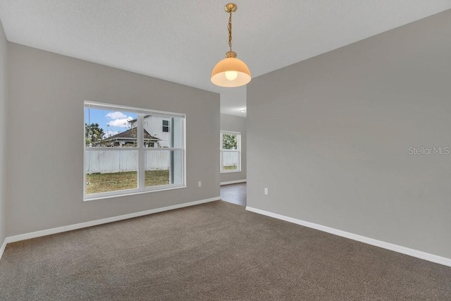 carpeted empty room featuring a textured ceiling