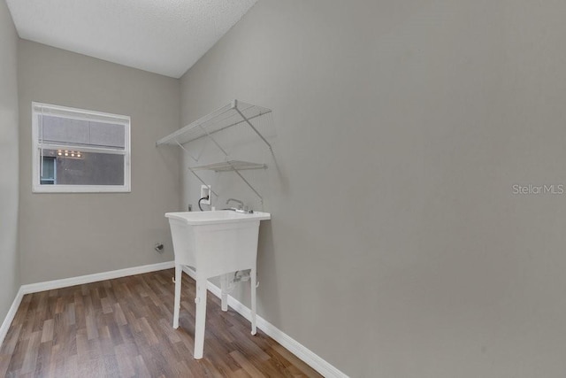 clothes washing area with washer hookup, hardwood / wood-style flooring, and a textured ceiling