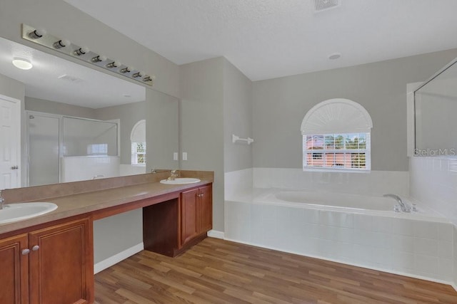 bathroom featuring vanity, shower with separate bathtub, hardwood / wood-style floors, and a textured ceiling