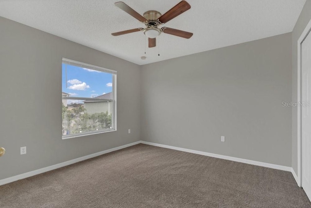 carpeted empty room featuring ceiling fan and a textured ceiling