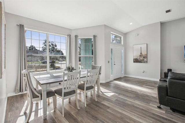 dining room with hardwood / wood-style flooring, lofted ceiling, and plenty of natural light