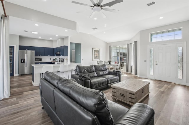 living room featuring sink, dark wood-type flooring, ceiling fan, and vaulted ceiling