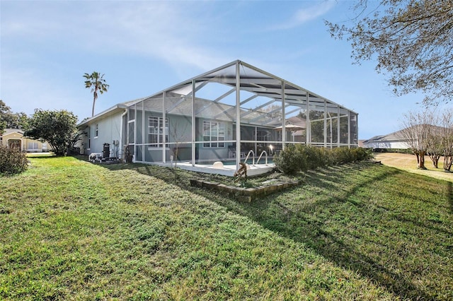 rear view of property with a lanai and a yard