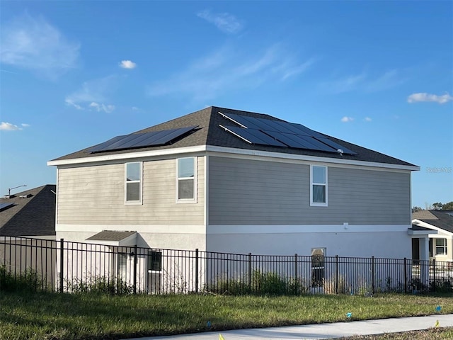 view of side of home with solar panels