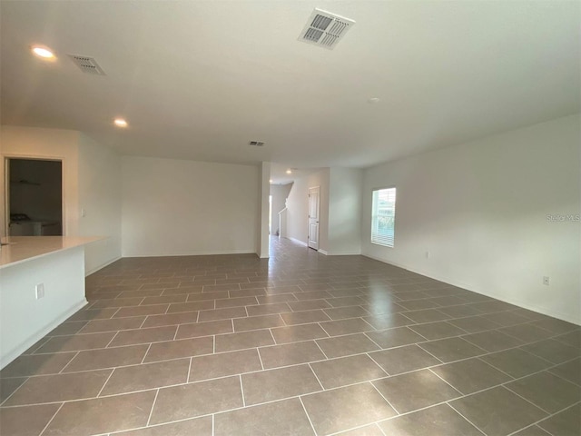 unfurnished living room featuring dark tile patterned flooring