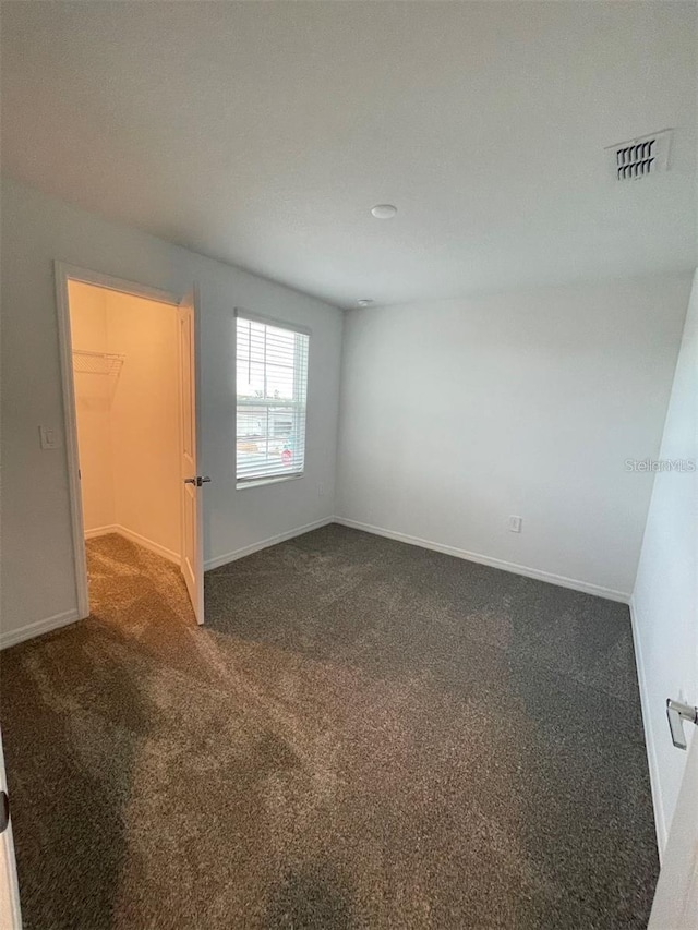 empty room with dark colored carpet