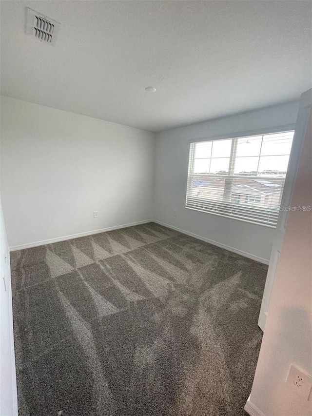 empty room featuring dark colored carpet