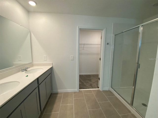 bathroom featuring vanity, tile patterned flooring, and a shower with door