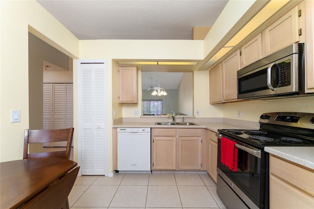 kitchen with appliances with stainless steel finishes, sink, light brown cabinets, and light tile patterned floors