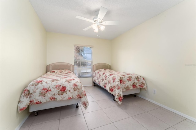 bedroom with light tile patterned floors, a textured ceiling, and ceiling fan