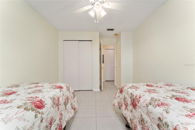 tiled bedroom featuring ceiling fan, a closet, and a textured ceiling