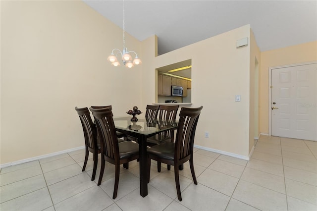 tiled dining area with an inviting chandelier and vaulted ceiling