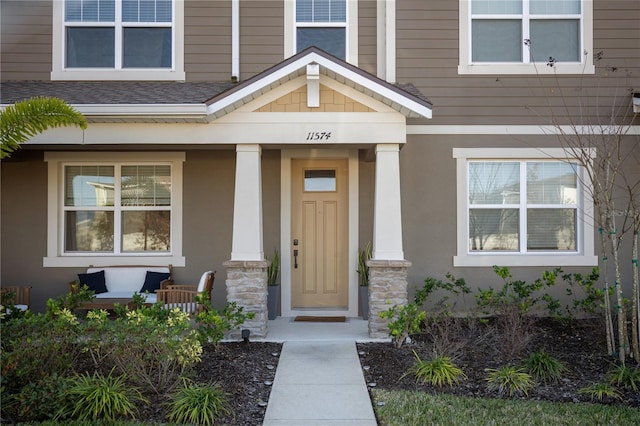 view of exterior entry featuring covered porch