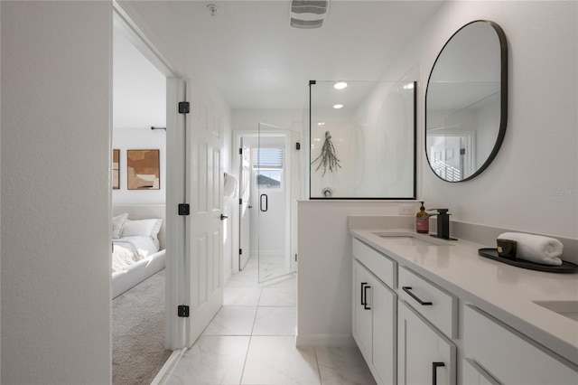 bathroom featuring a shower with door and vanity