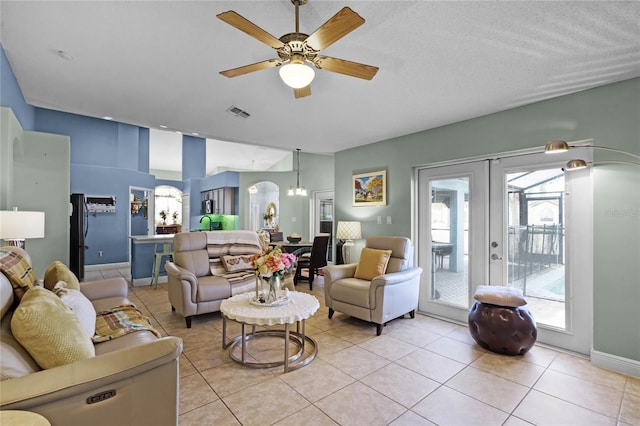 tiled living room featuring french doors and ceiling fan