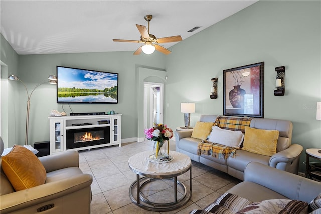 living room featuring lofted ceiling, light tile patterned floors, and ceiling fan