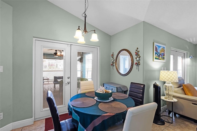 tiled dining room with lofted ceiling, plenty of natural light, french doors, and a chandelier