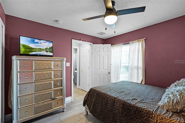 bedroom featuring ceiling fan, light hardwood / wood-style floors, and a textured ceiling