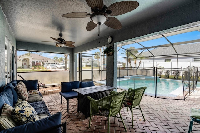 exterior space featuring a fenced in pool, outdoor lounge area, ceiling fan, and glass enclosure