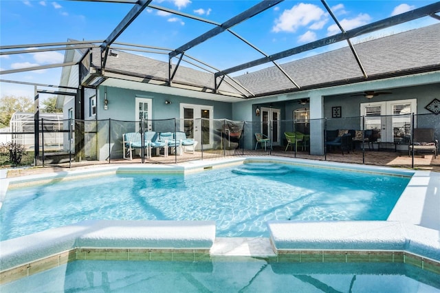 view of pool with a patio, glass enclosure, ceiling fan, and french doors