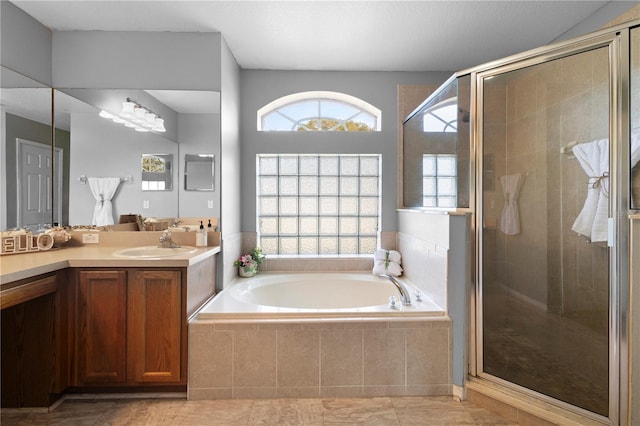 bathroom with vanity and shower with separate bathtub