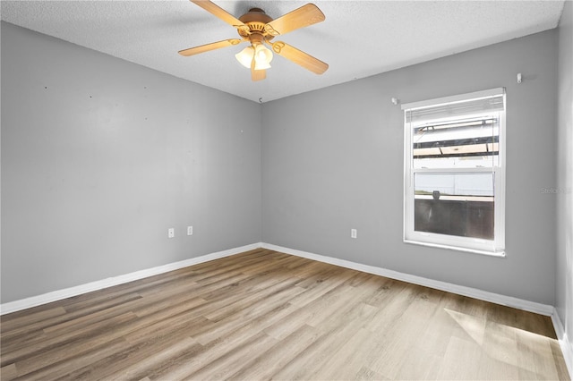 empty room with ceiling fan, a textured ceiling, and light wood-type flooring