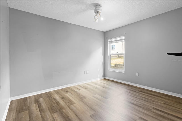 spare room featuring hardwood / wood-style flooring and a textured ceiling