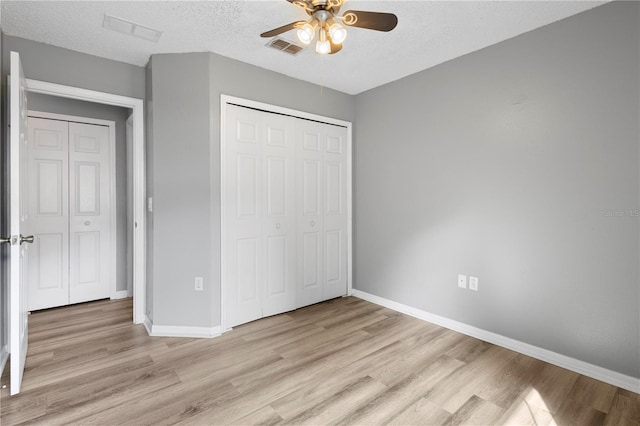 unfurnished bedroom with a closet, ceiling fan, a textured ceiling, and light hardwood / wood-style flooring