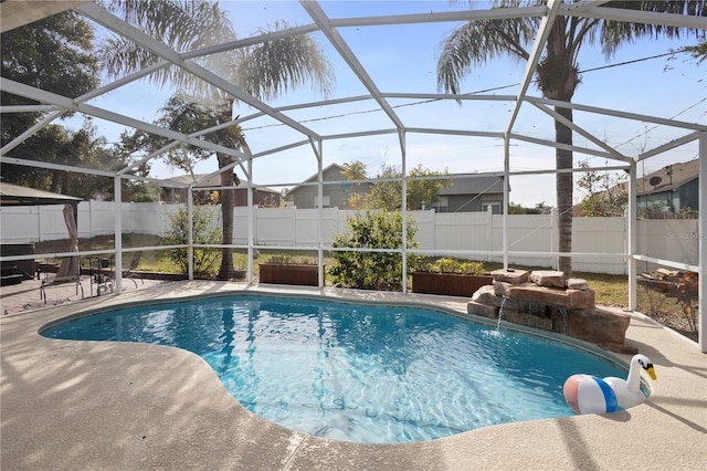 view of pool featuring pool water feature, a patio area, and a lanai