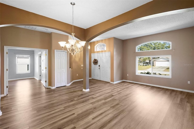 interior space with hardwood / wood-style floors, a textured ceiling, and an inviting chandelier