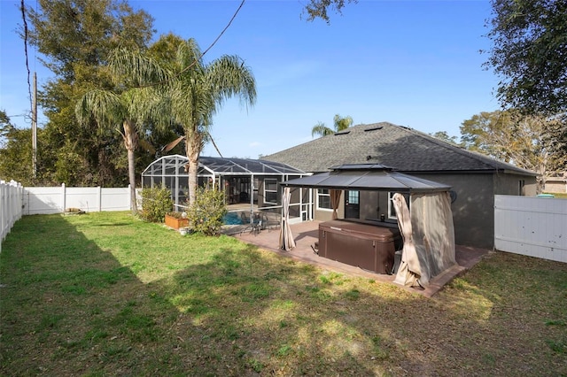 rear view of property featuring a patio, a swimming pool with hot tub, a lanai, a yard, and a gazebo