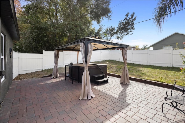 view of patio with a hot tub and a gazebo