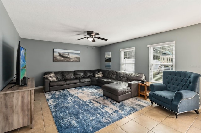 living room featuring light tile patterned floors, a textured ceiling, and ceiling fan