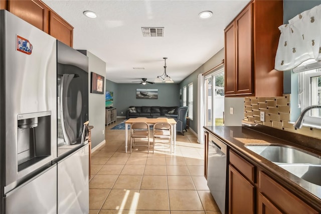 kitchen featuring stainless steel appliances, light tile patterned flooring, plenty of natural light, and sink