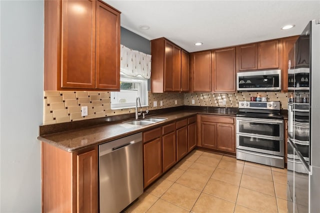 kitchen featuring stainless steel appliances, sink, light tile patterned floors, and backsplash