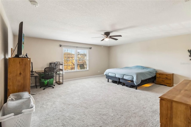 carpeted bedroom featuring ceiling fan and a textured ceiling